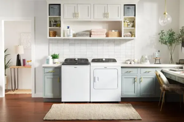 A Whirlpool top load washer and dryer set in a laundry room